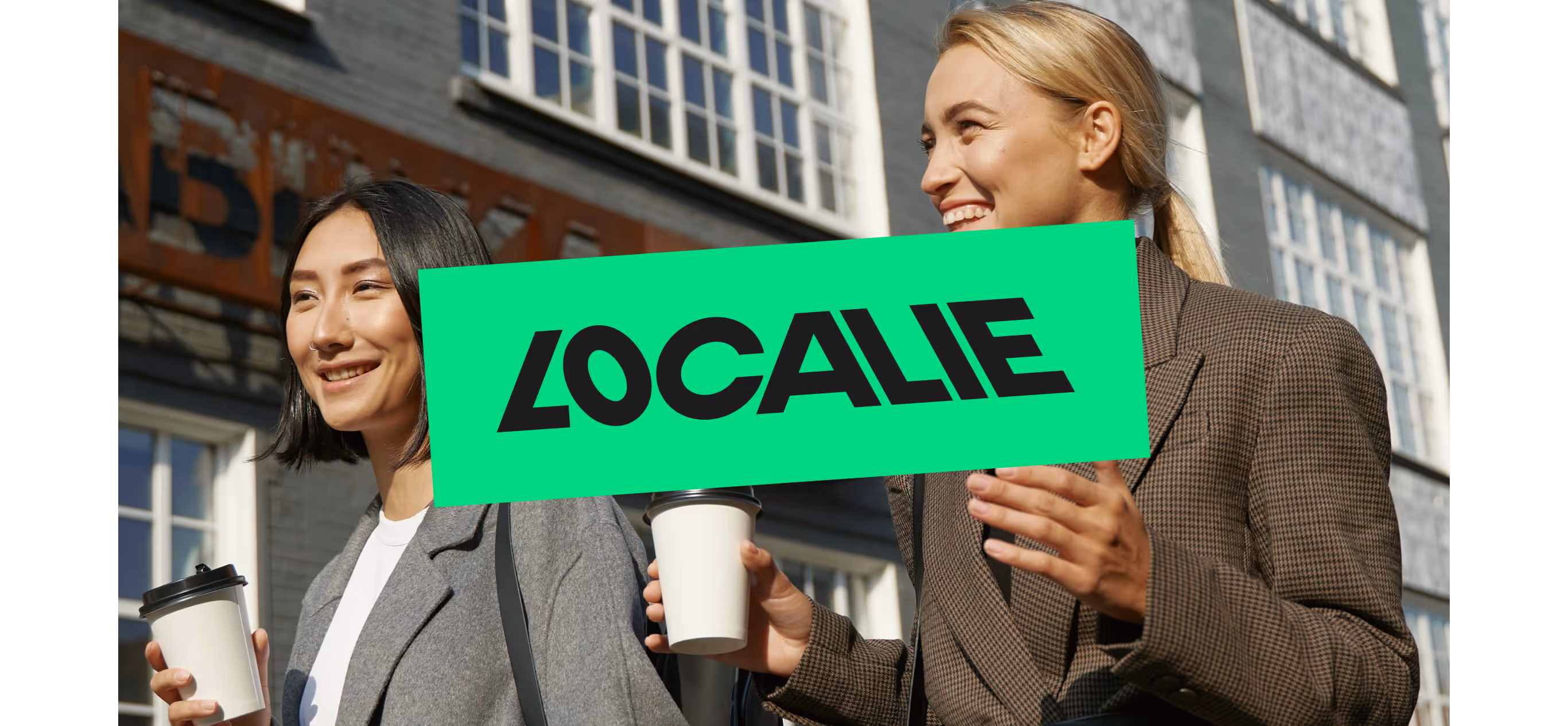 Two women holding a Localie sign in the street