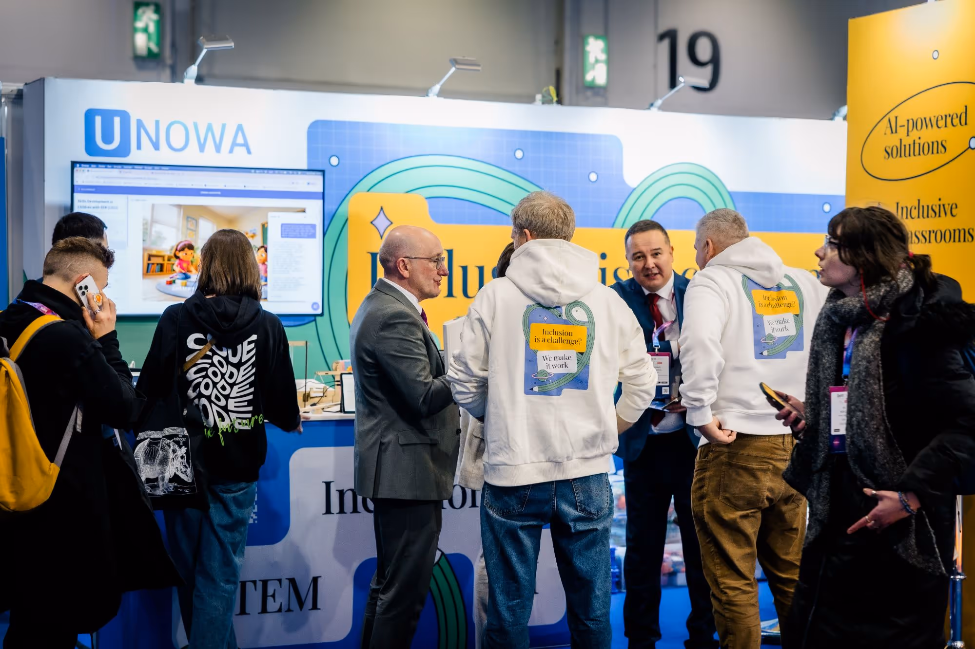 Visitors at the UNOWA stand at BETT, the team in branded hoodies