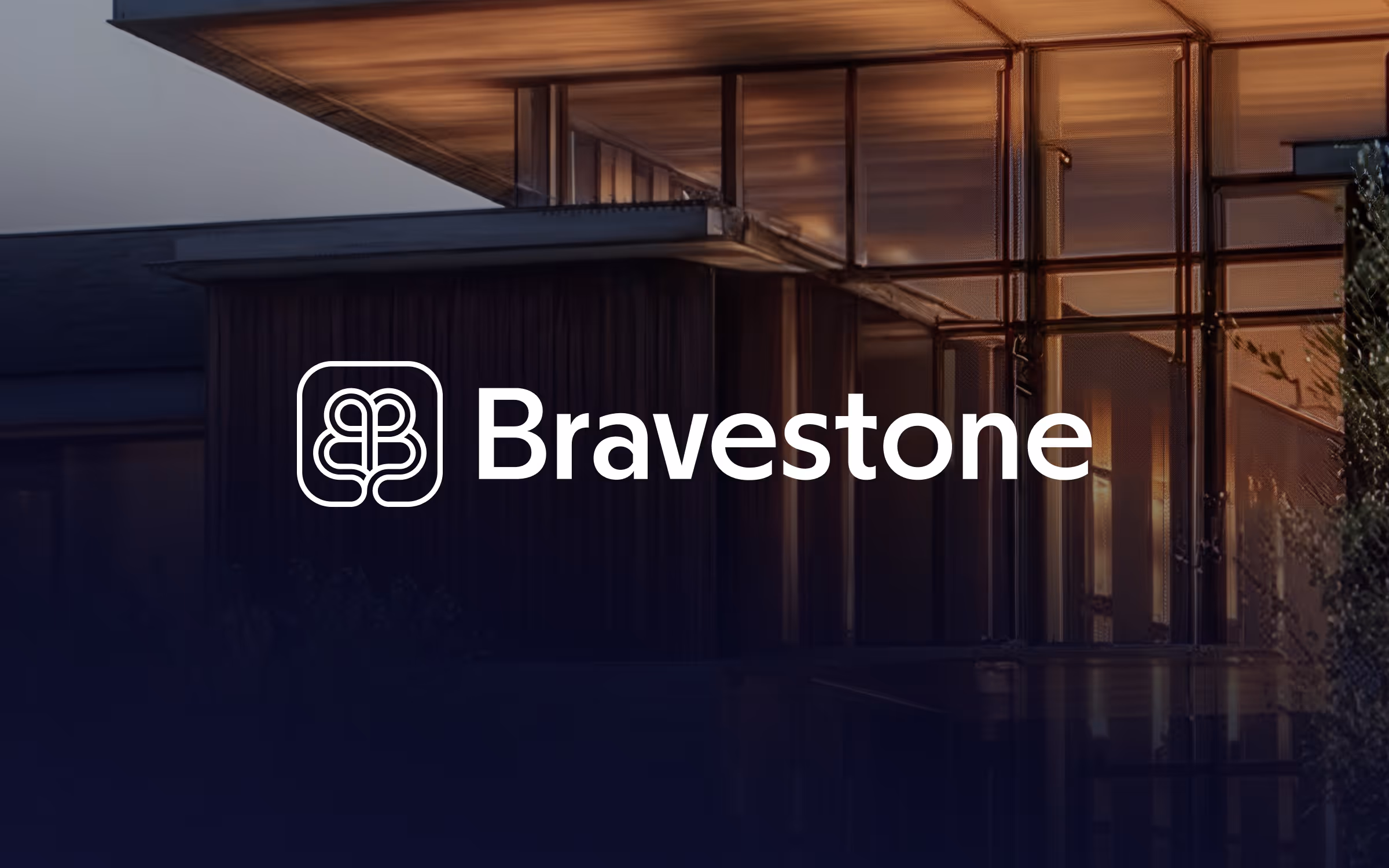 Bravestone logo on a glass office facade at dusk